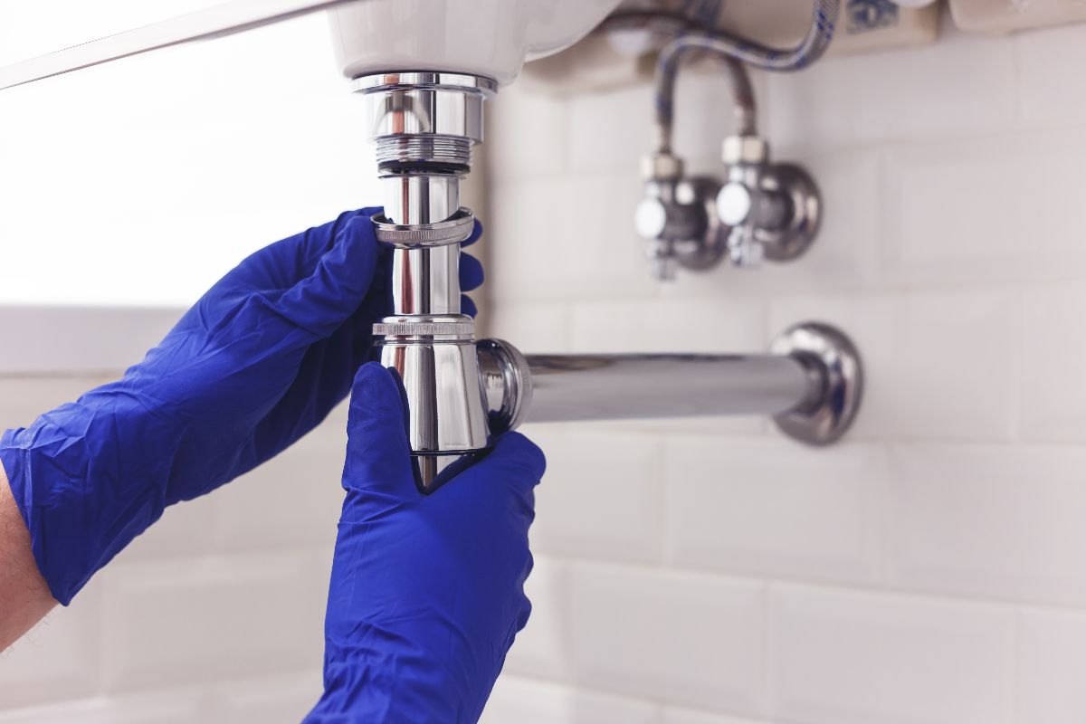 Plumber Fixing Sink In Bathroom