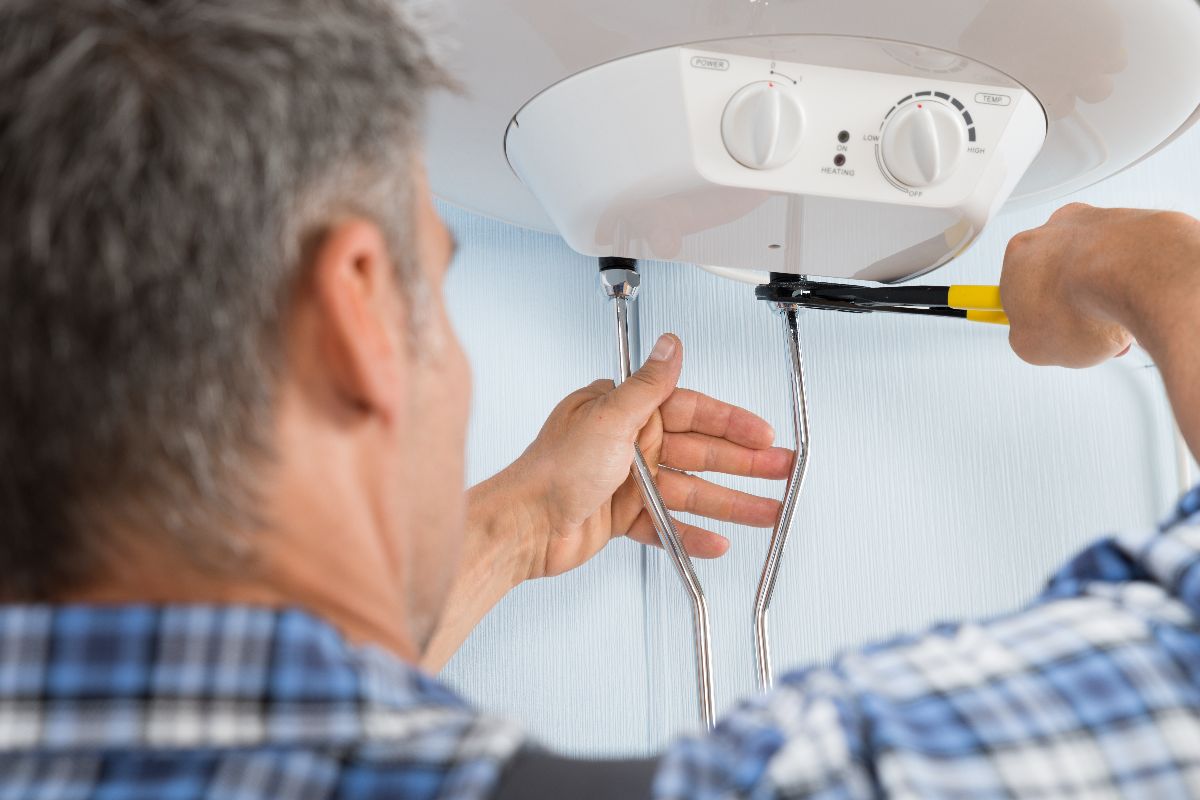 Plumber Fixing a Water Heater Plumber Fixing a Water Heater